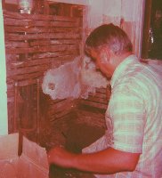 Dad cutting away rotten flooring at kitchen sink